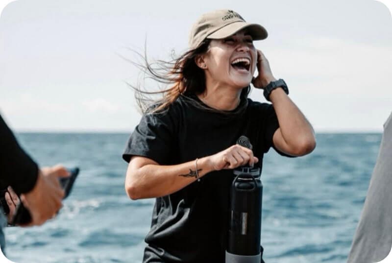Mujer sonriendo con gorra y botella de agua